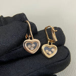 Rose-gold tone heart earrings with three round diamonds and heart drop charm