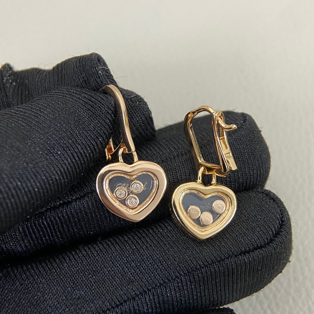 Rose-gold tone heart earrings with three round diamonds and heart drop charm