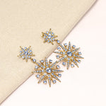 Light blue crystal star drop earrings, gold-tone with eight-pointed star studs.