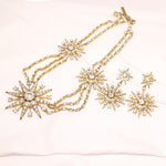 Gold-tone crystal star drop earrings with multiple eight-pointed stars in a linked chain.