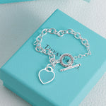 Silver bracelet with blue enamel heart charm and bar toggle clasp