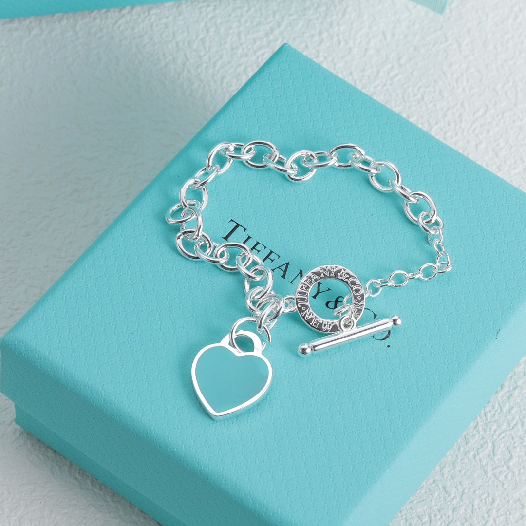 Silver bracelet with blue enamel heart charm and bar toggle clasp