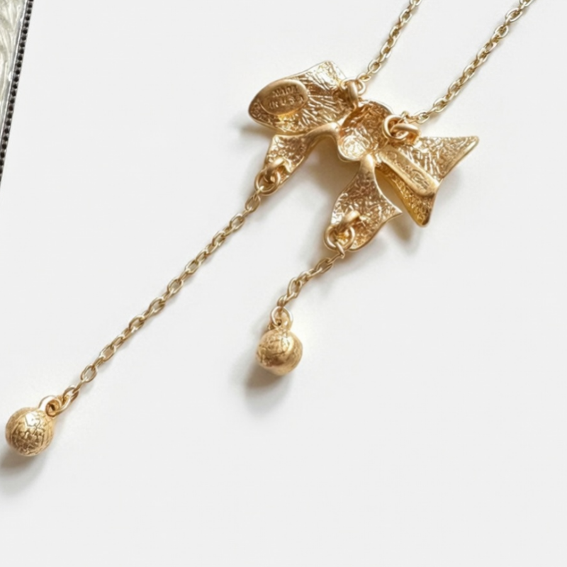 Vintage bow crystal tassel necklace with gold-tone chain and dangling charm drops