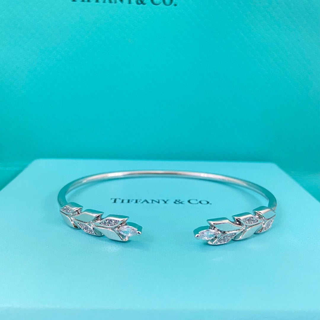 White gold-tone open leaf bangle with diamond-encrusted leaf details