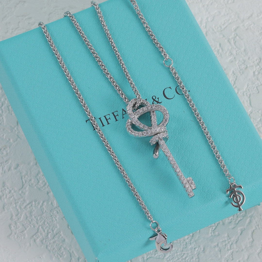 White gold pavé knot key pendant necklace with linked chain and key charm
