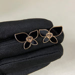 Butterfly enamel earrings with black petals, heart center charm, and gold-tone prongs