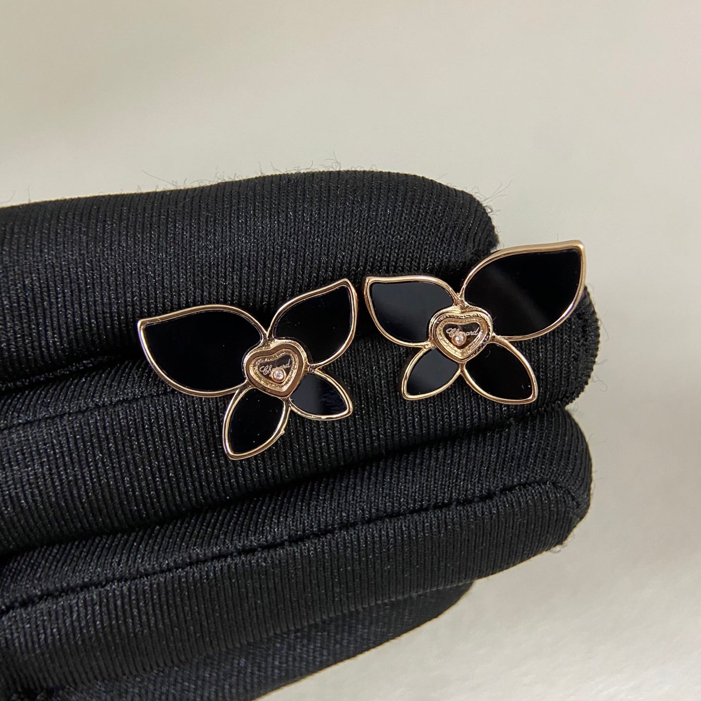 Butterfly enamel earrings with black petals, heart center charm, and gold-tone prongs