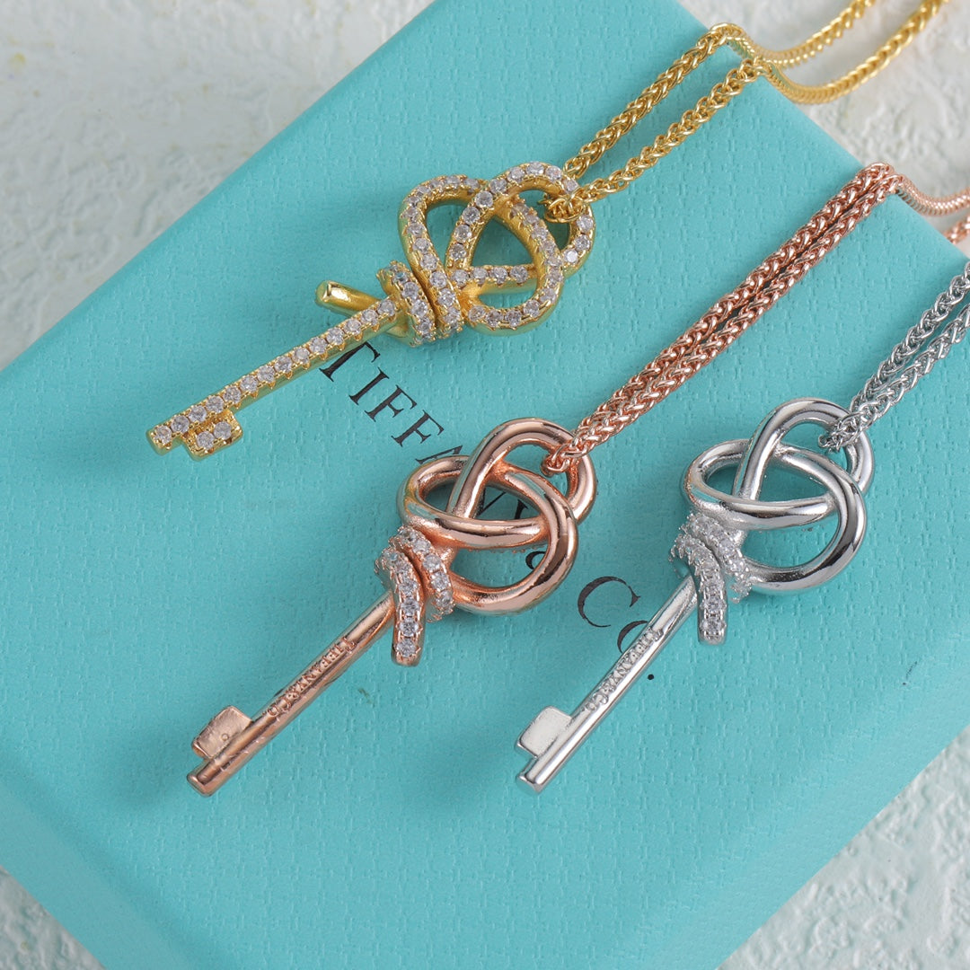 Gold key knot pendant necklace with pavé crown-like ring detail and key charms
