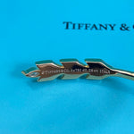 Close-up underside of gold-tone open leaf bangle with engraved markings