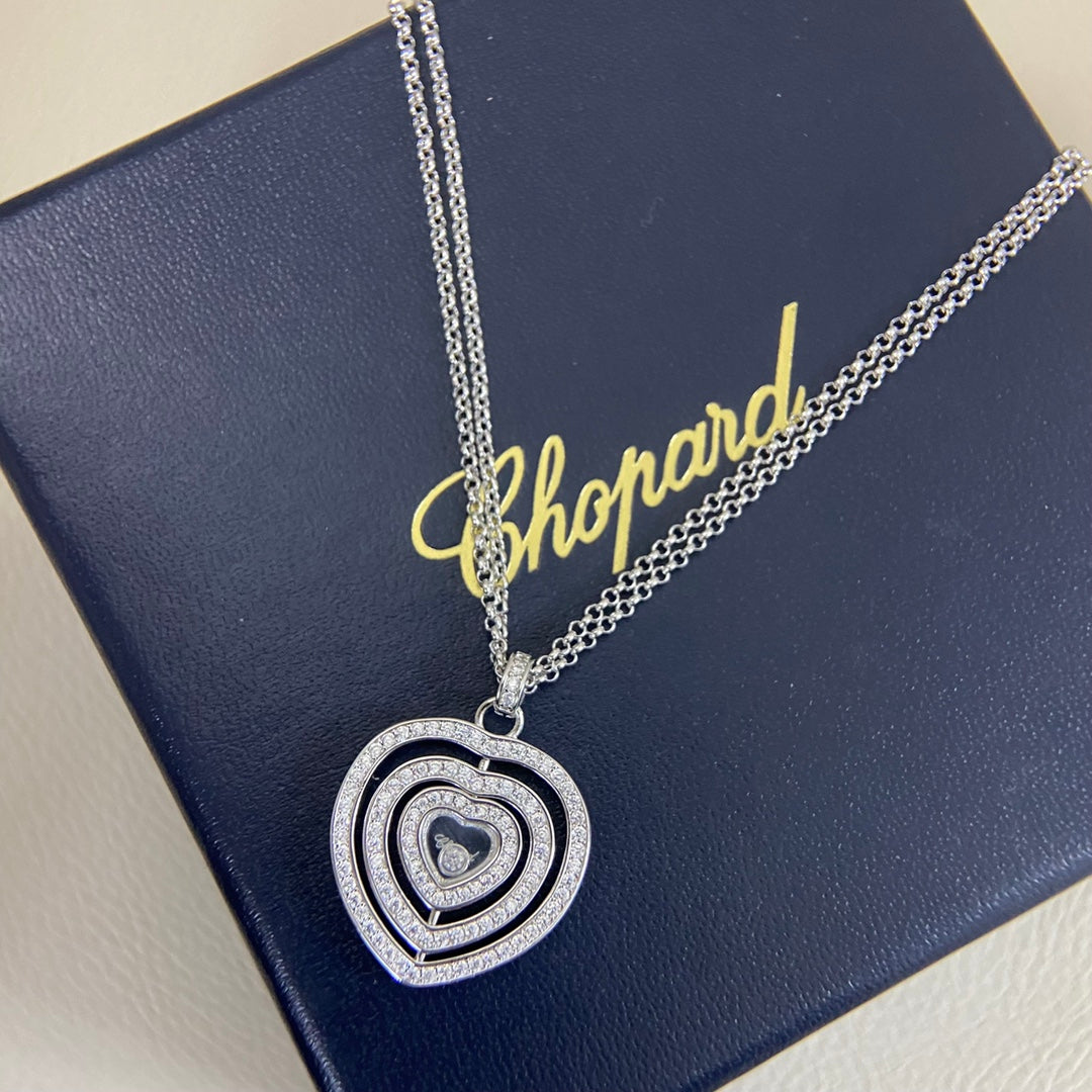 Heart pendant necklace with diamond pavé triple-heart design on a silver chain