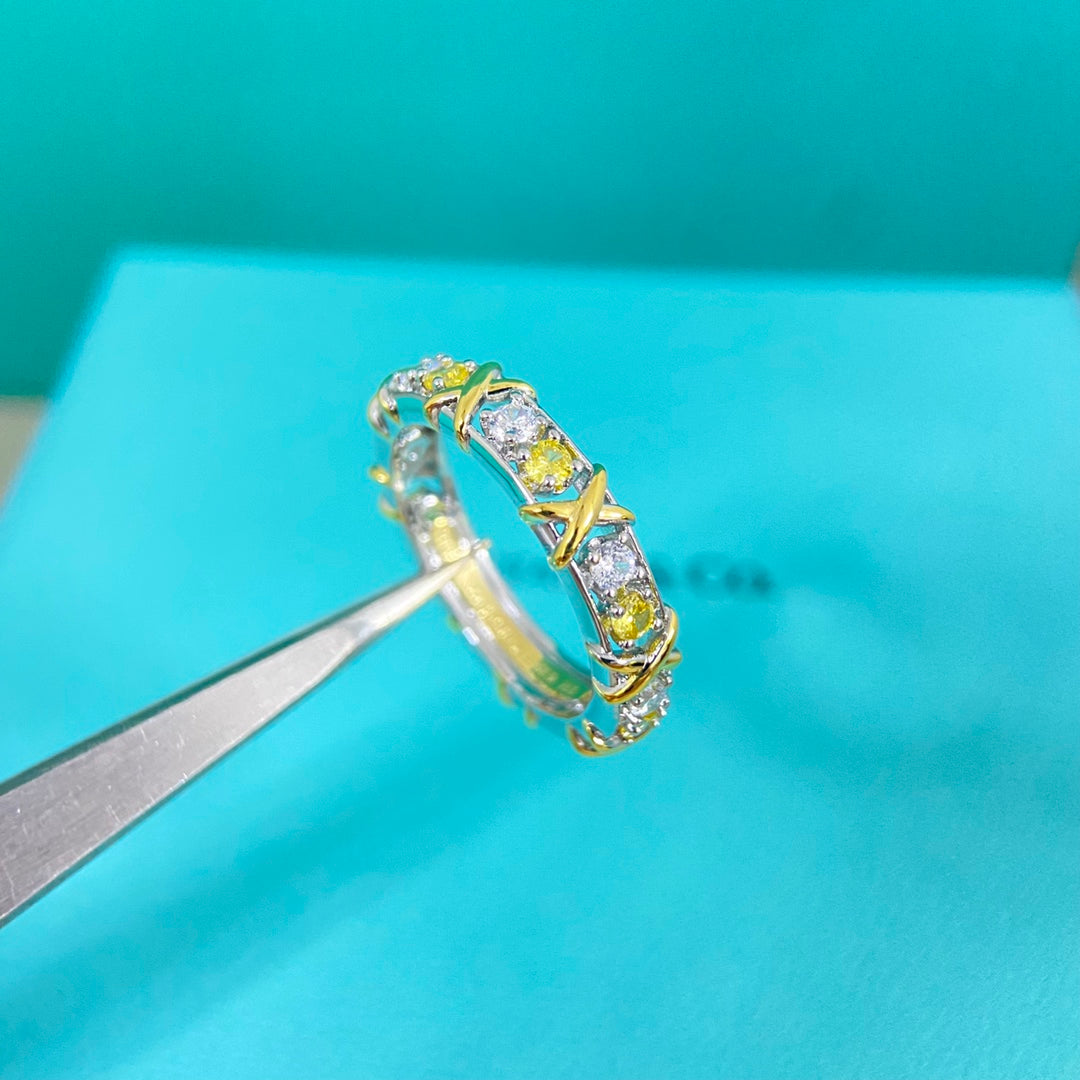 Two-tone diamond-set ring close-up, prong-set clear and yellow stones on band