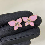 Butterfly enamel earrings with pink petals, heart center charm, and gold-tone prongs
