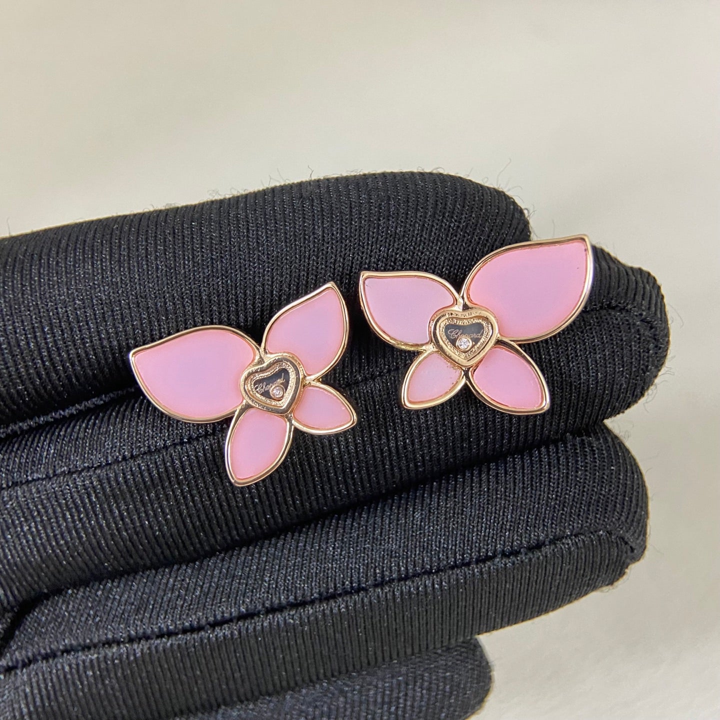Butterfly enamel earrings with pink petals, heart center charm, and gold-tone prongs