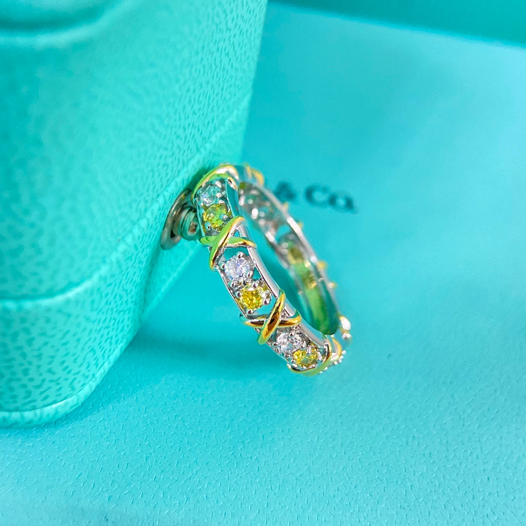 Two-tone diamond-set ring from side, alternating clear and yellow gemstone settings