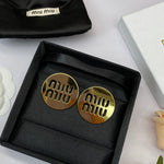 Round gold metal stud earrings with miu miu logo cutouts