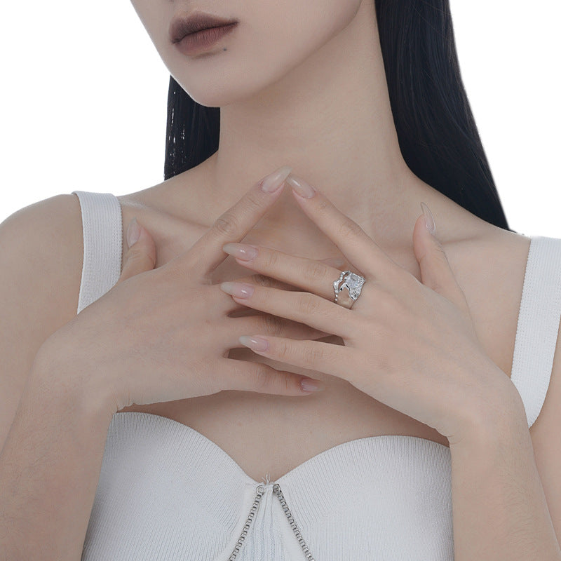 Sterling silver molten-style ring with clear center stone worn on hand