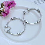 White-gold tone high-shine 3D logo round hoop earrings, hinged clasp, metal