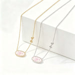 Gold-tone bow charm oval pendant necklace with pink floral enamel