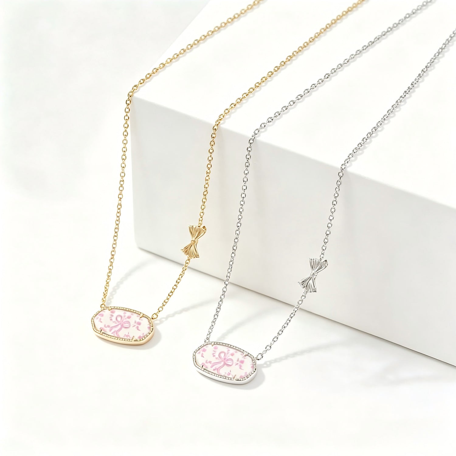 Gold-tone bow charm oval pendant necklace with pink floral enamel