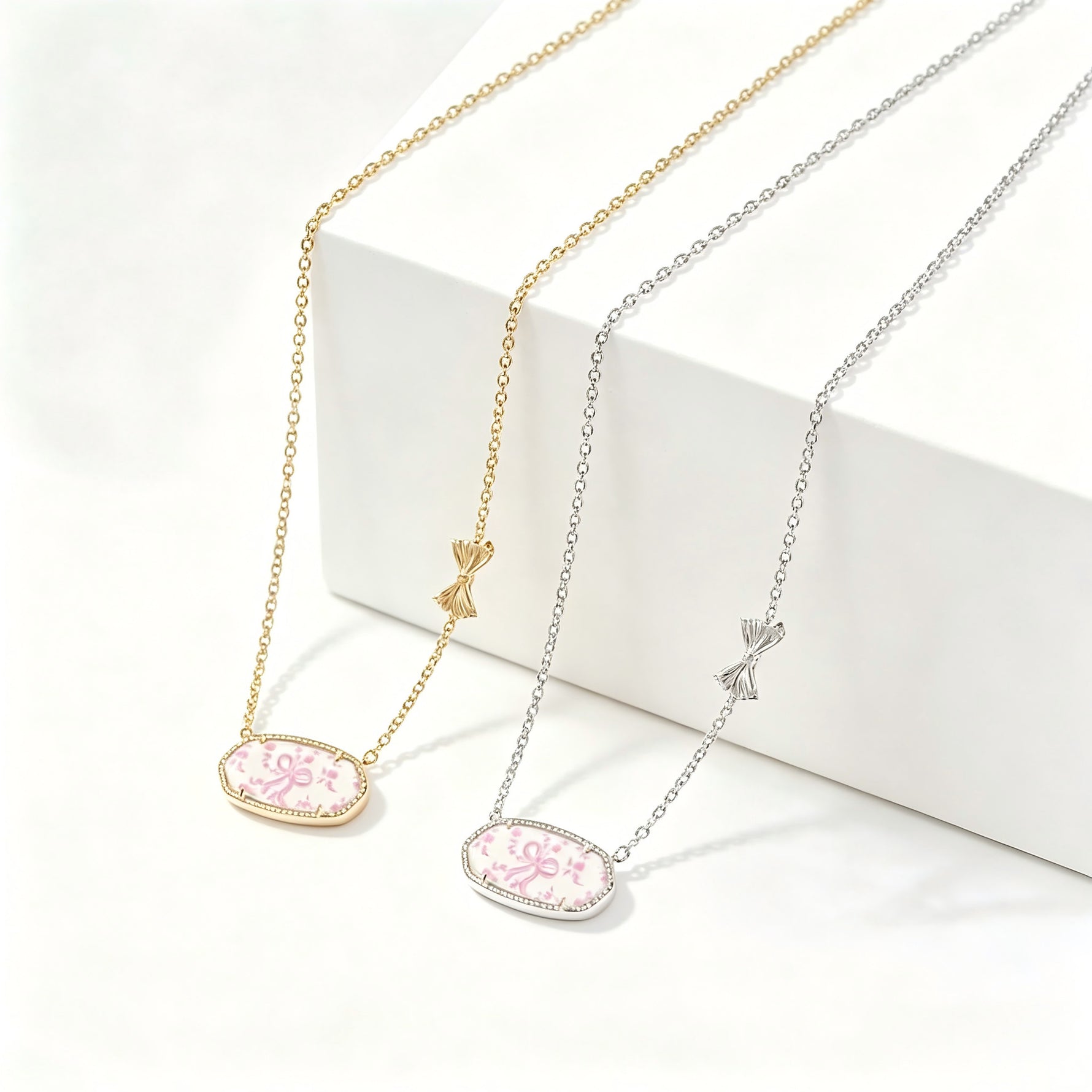 Gold-tone bow charm oval pendant necklace with pink floral enamel