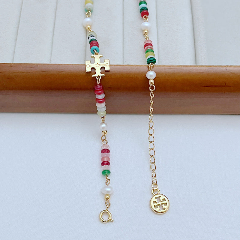 Halskette im Detail: bunte Perlen mit Süßwasserperlen und goldenen T-Charm-Anhängern