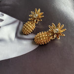 Gold flower diamond earrings with clear center stones and textured gold pineapple drops