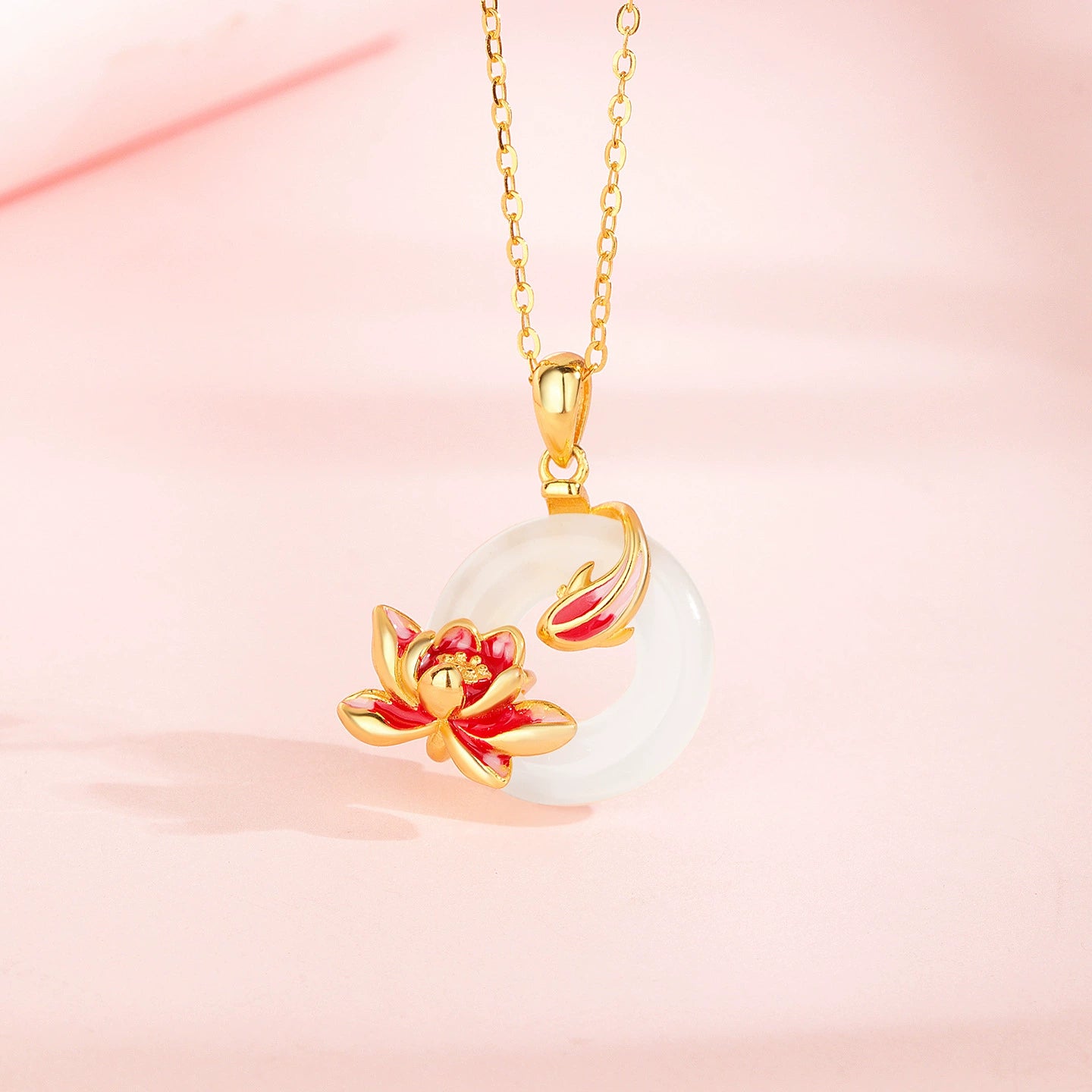 Gold-tone necklace with round white gemstone pendant, red flower and red leaf accent