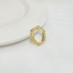 Gold-tone ring with open round bezel and small rhinestone accents