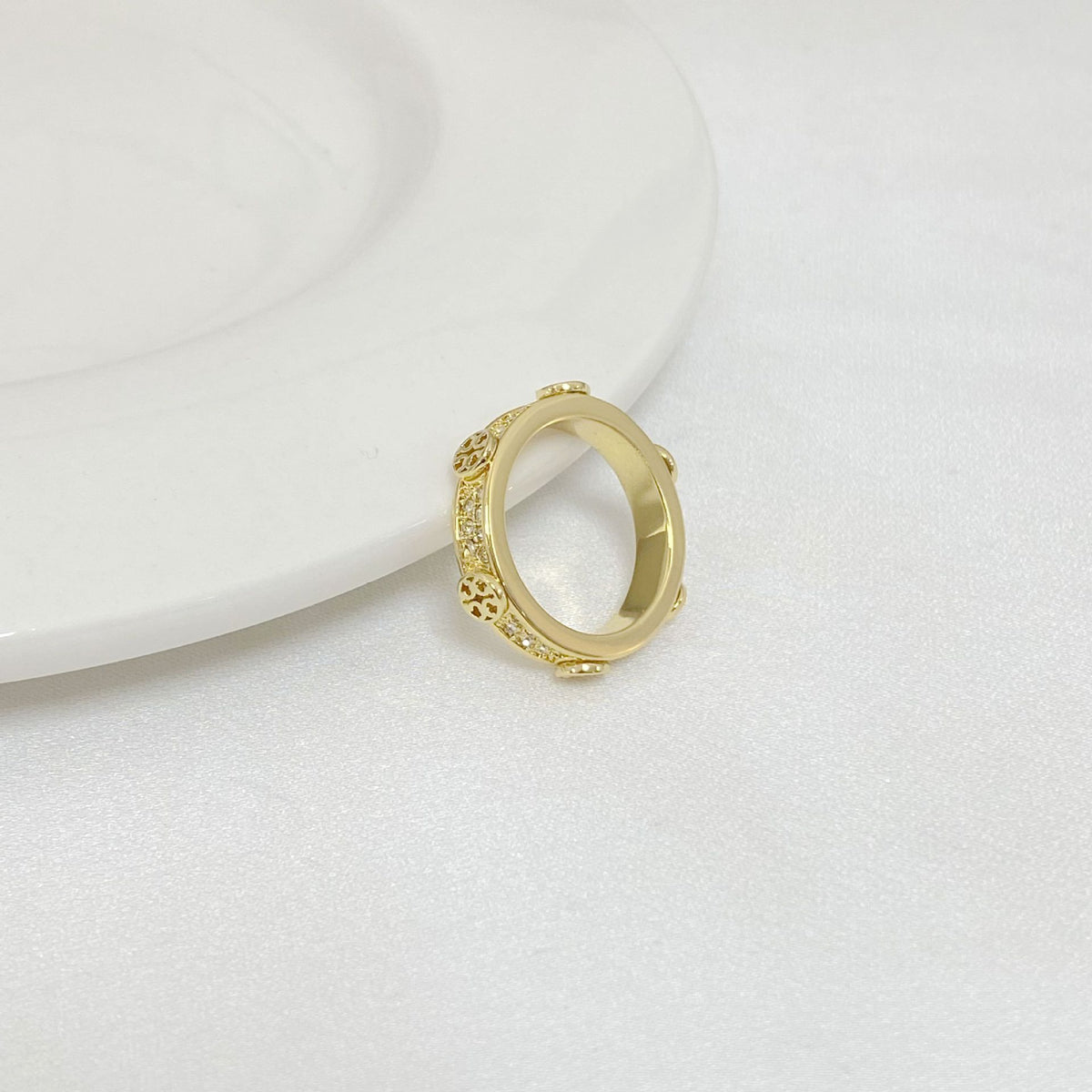 Gold-tone ring with open round bezel and small rhinestone accents