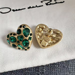 Back view of gold-tone heart stud earrings with green crystal front and butterfly clasp