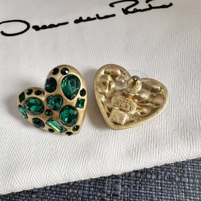 Back view of gold-tone heart stud earrings with green crystal front and butterfly clasp