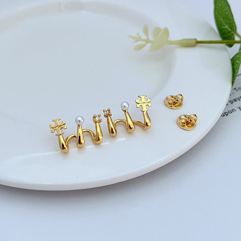 Gold M-shaped metal stud earrings, pearl detail at the top