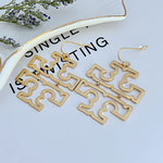 Gold long chandelier earrings with linked openwork logo charms and hook closures