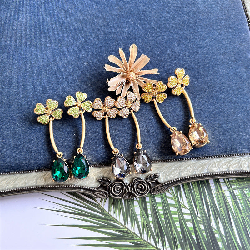 Gold-tone four-leaf clover crystal drop earrings with teardrop champagne and clear stones