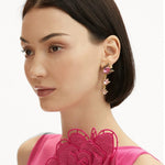 Rose-pink floral zircon drop earrings with gold-tone details on model