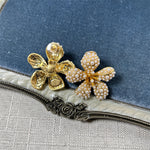 White pearl five-petal flower earrings on gold-tone posts with teardrop details
