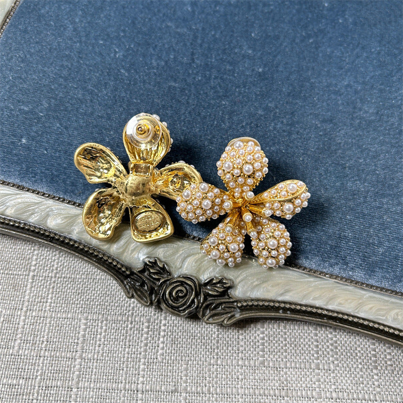 White pearl five-petal flower earrings on gold-tone posts with teardrop details