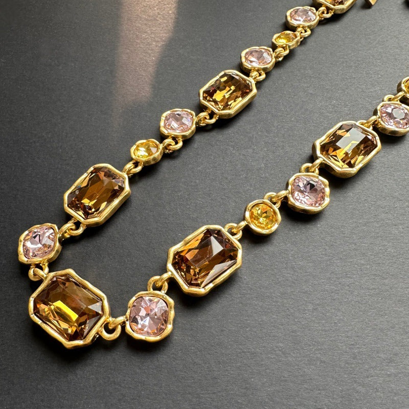 Detailansicht: goldfarbene Halskette mit großen quadratischen Champagne-Kristallen