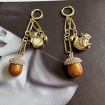 Gold drop earrings with squirrel and pinecone charms, jeweled cap tassel and gold hooks