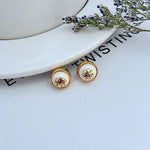 Round logo resin stud earrings, white resin discs with gold-tone bezel