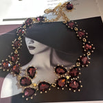 Gold-tone link crystal necklace with dark red oval and marquise faceted stones