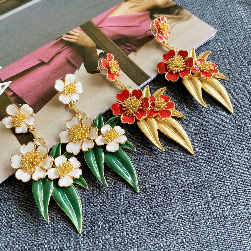 Red enamel floral drop earrings with gold beaded flowers and pointed gold leaf details