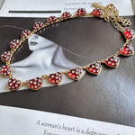 Red rhinestone heart necklace with gold-tone chain and small heart charms