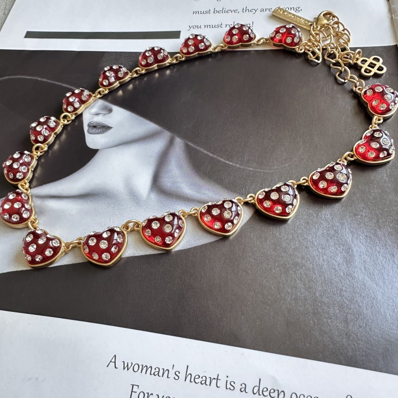 Red rhinestone heart necklace with gold-tone links and heart pendant charms