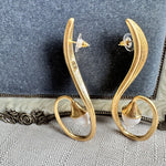Gold-tone clip-on earrings back view: oval hoops with white bell flower and posts