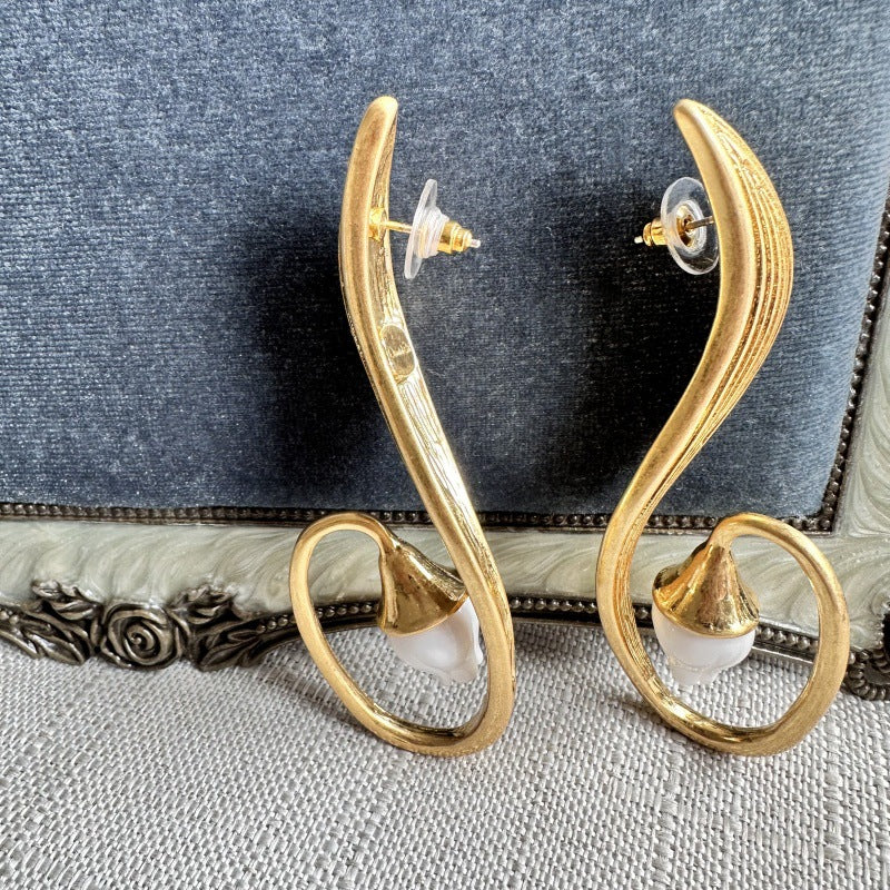 Gold-tone clip-on earrings back view: oval hoops with white bell flower and posts
