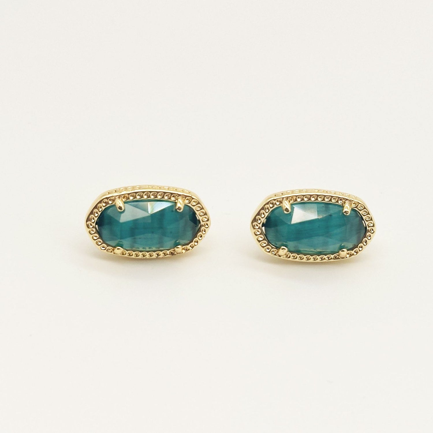 Oval gemstone stud earrings with teal crystal in gold-tone bezel setting