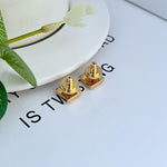 Gold square logo earrings with posts and backs, cube-like stud shape