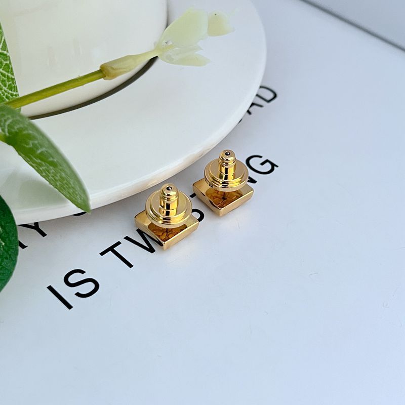 Gold square logo earrings with posts and backs, cube-like stud shape