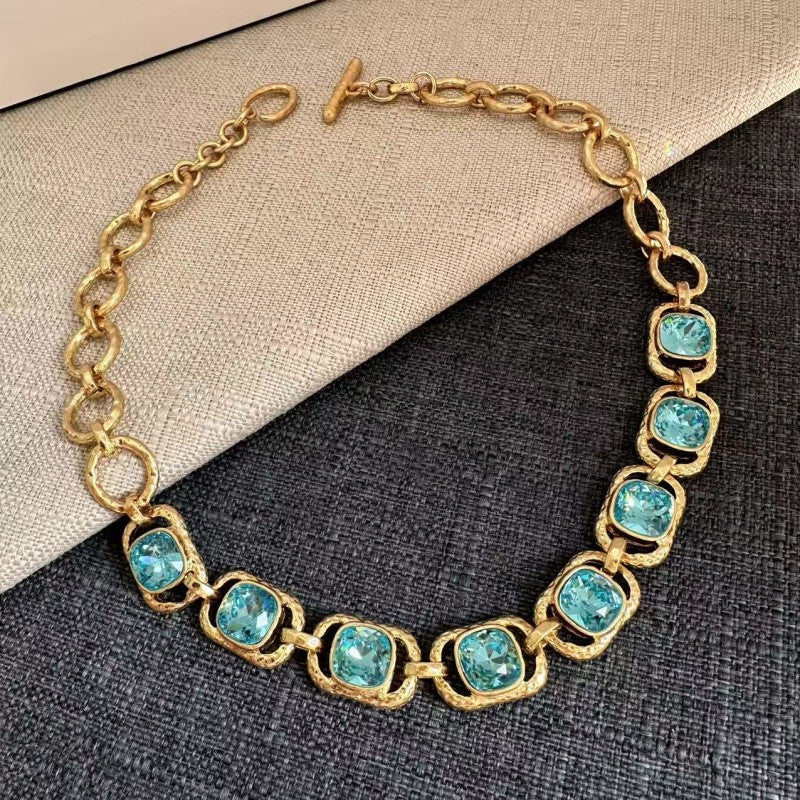 Gold link necklace with turquoise-blue faceted crystal oval stations